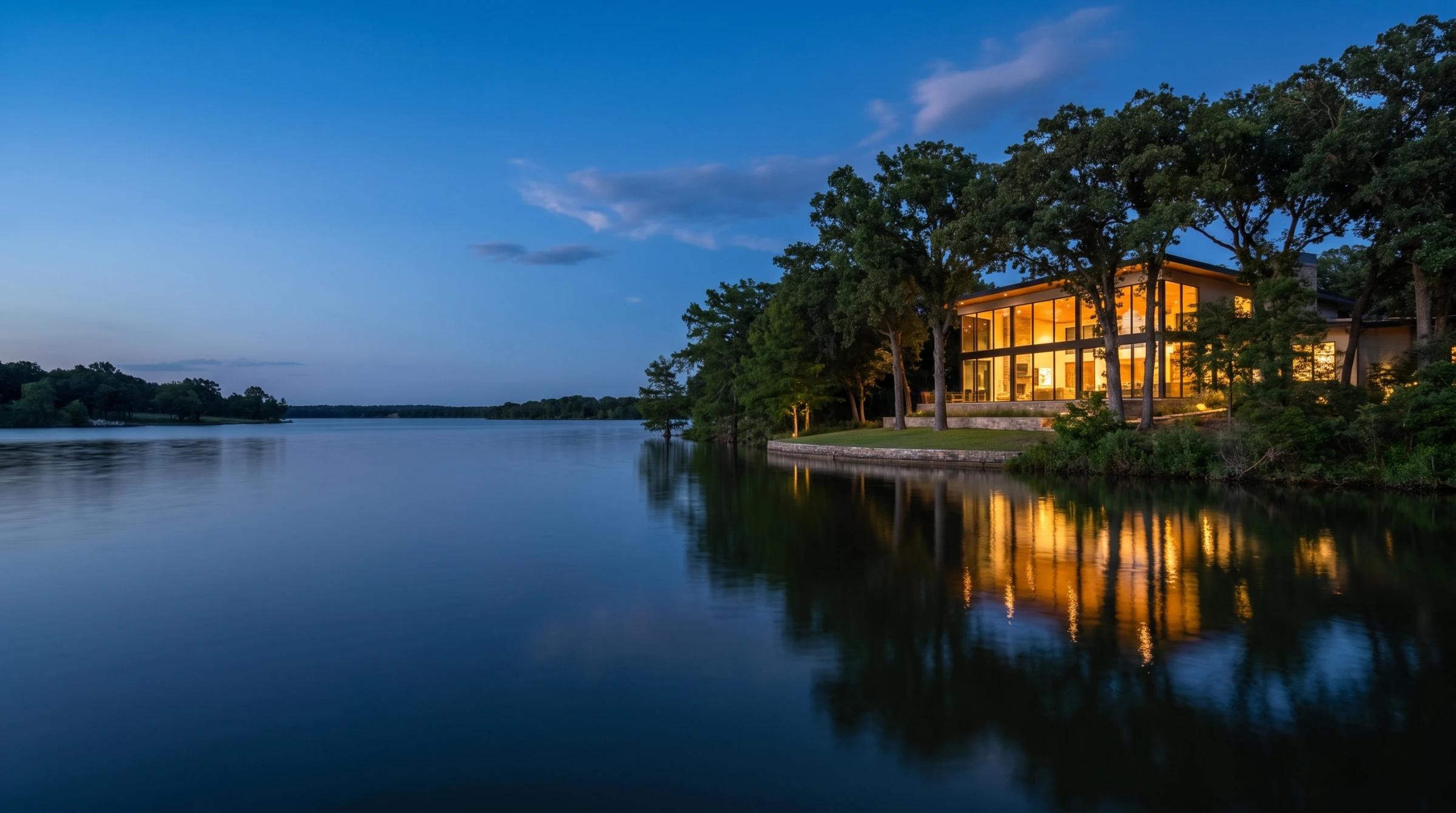 Conceptual lakeside residence at Cypress Point at blue hour, with warm interior light reflecting on Bois D'Arc Lake